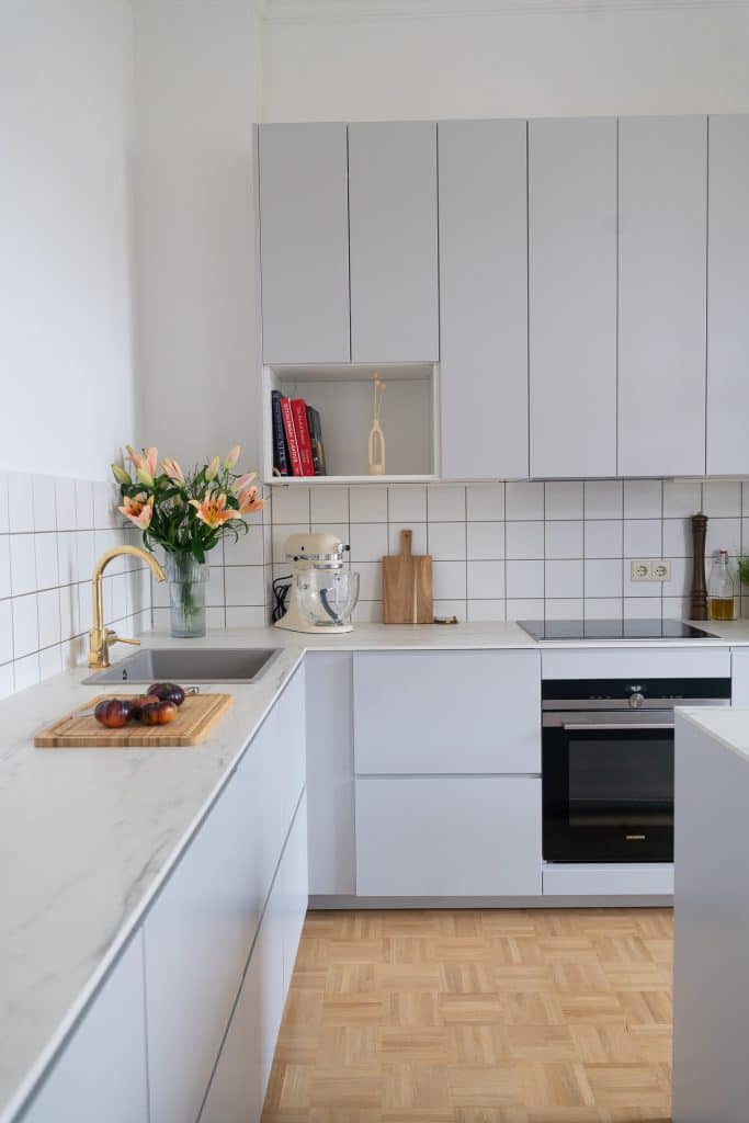 Profilansicht einer hellgrauen Küche mit Schränken an den Wänden