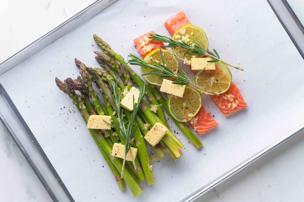 Top view of two cobblestones and salmon with raw green asparagus