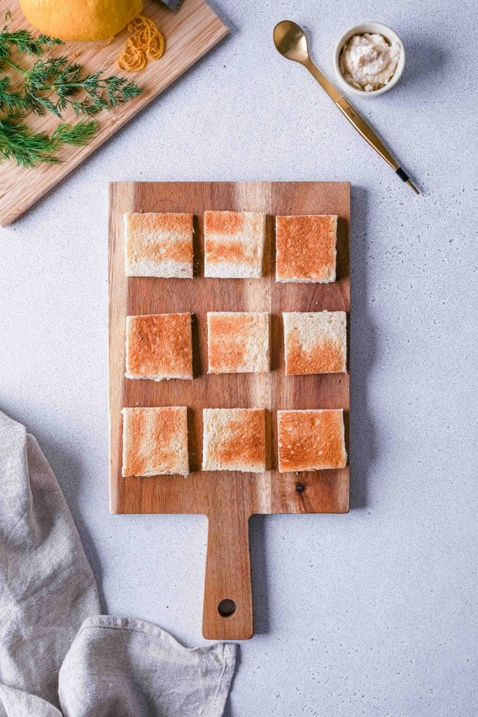 Cutting board dressed mini toast to prepare canapés
