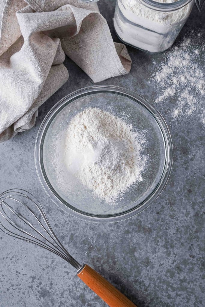 Zoom on a mixing bowl with flour, baking powder and salt
