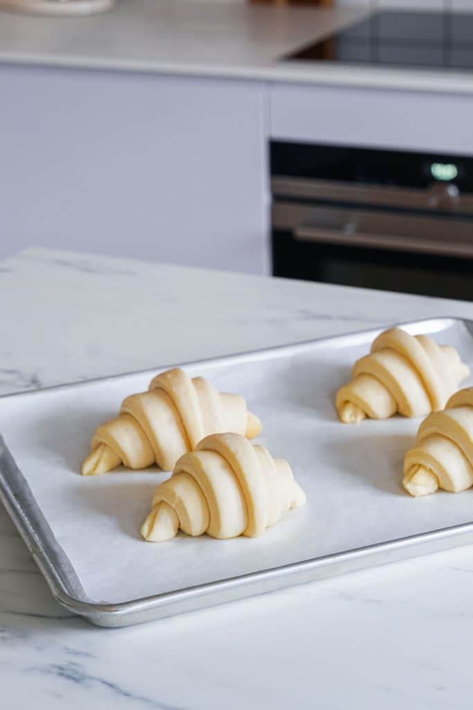 Zoom on a baking tray with 4 unbaked croissants