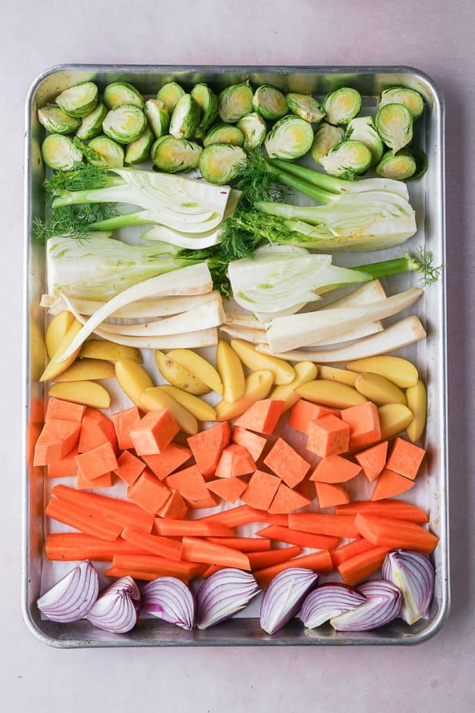 View on sheet pan with a rainbow of raw winter vegetables.