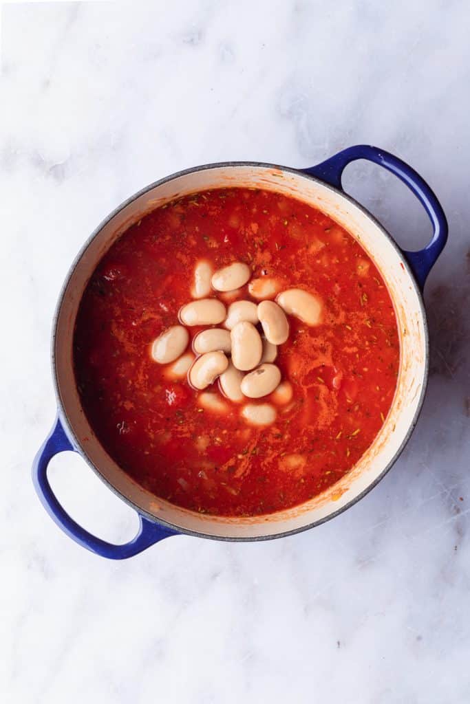 A pot of tomato soup with white beans