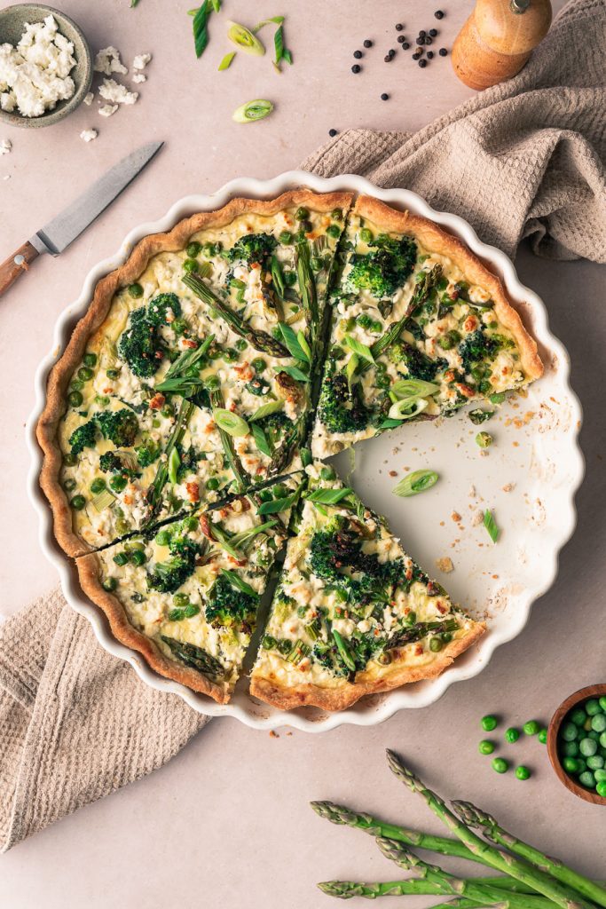 Spring quiche with asparagus, broccoli and peas cut in slices.