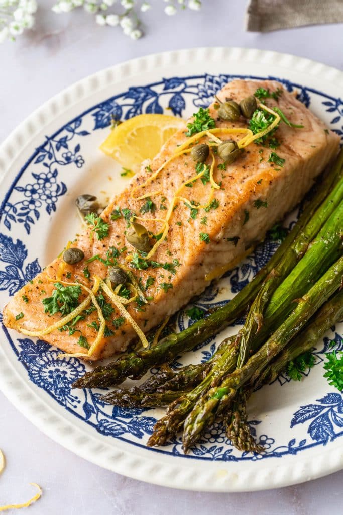 Zoom on one fillet of salmon meunière served with green asparagus
