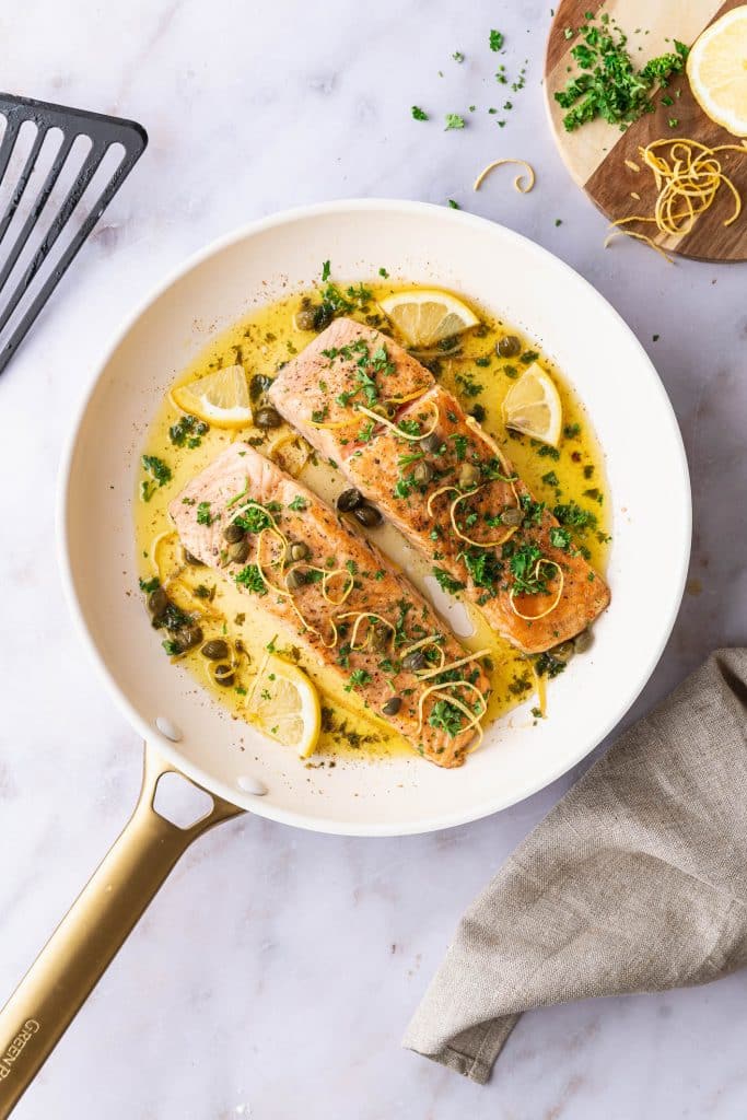 Zoom on two fillets of salmon meunière with capers and lemon zest
