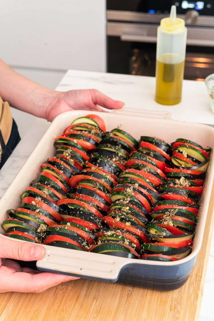Someone holding a vegetable tian before baking