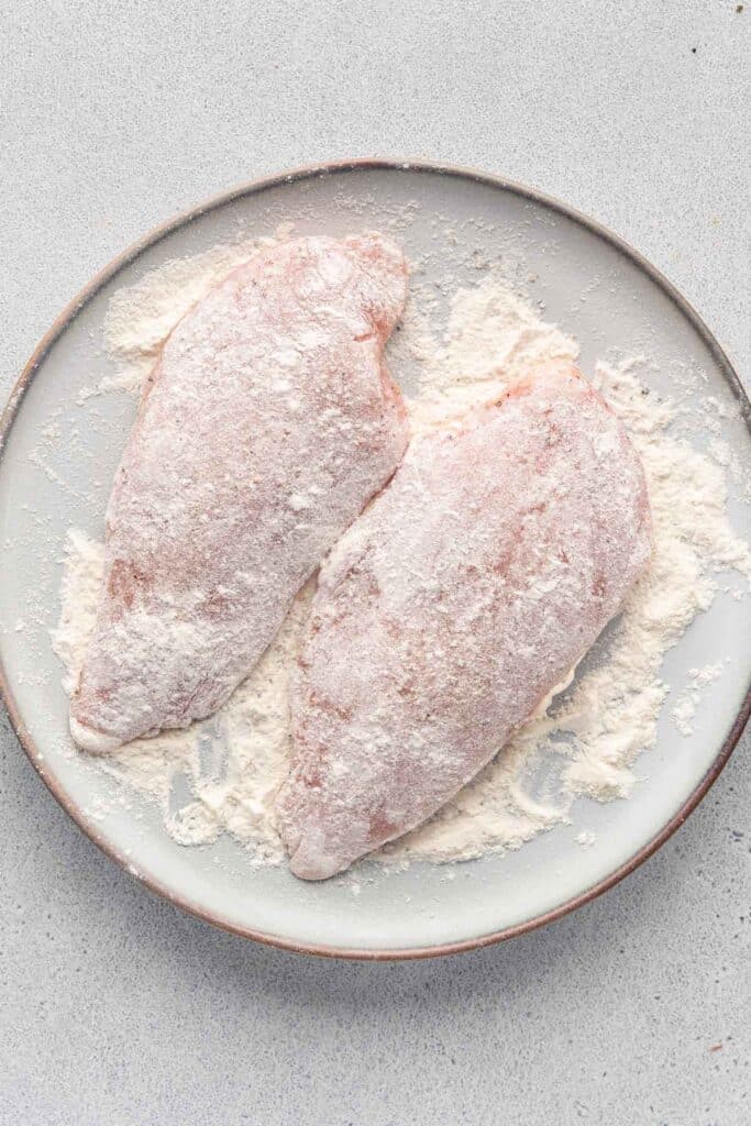 Two chicken breasts covered with flour 