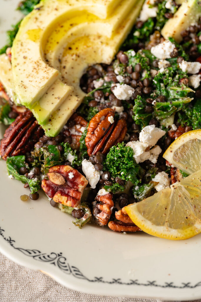 Zoom on plate of Kale and Lentil Salad with Avocado, feta and pecan nuts 