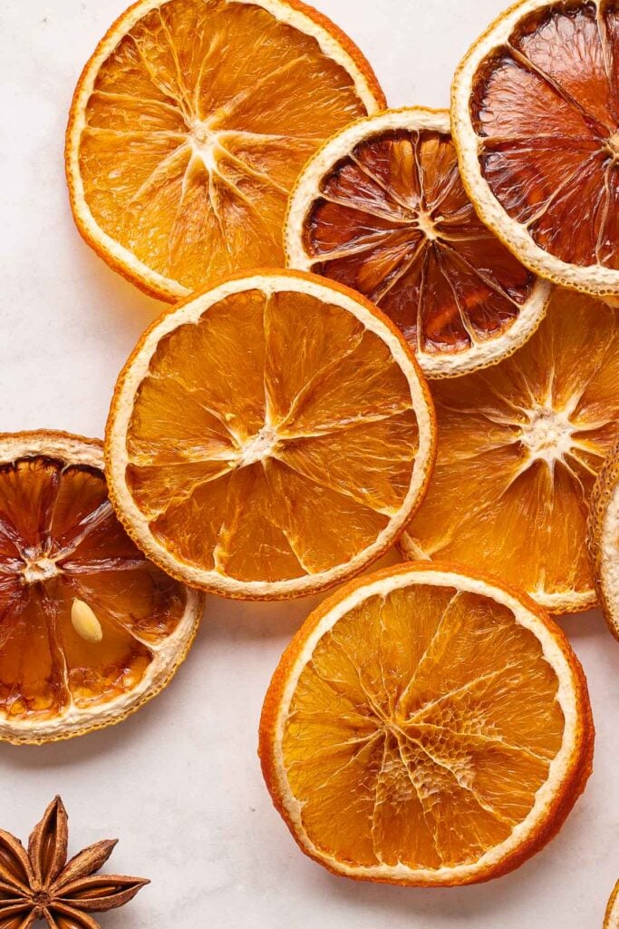 Slices of dried oranges and lemons arranged on a light surface.