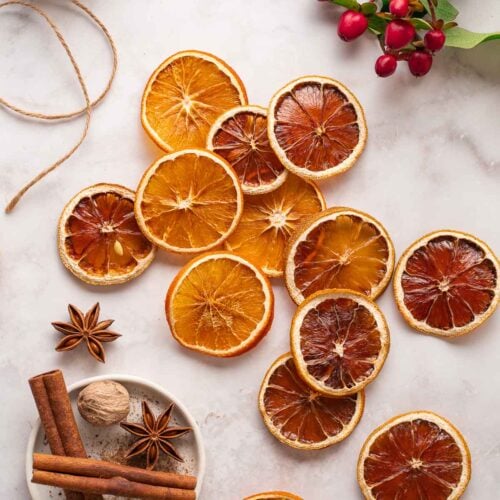 Slices of dried oranges and lemons arranged on a light surface.