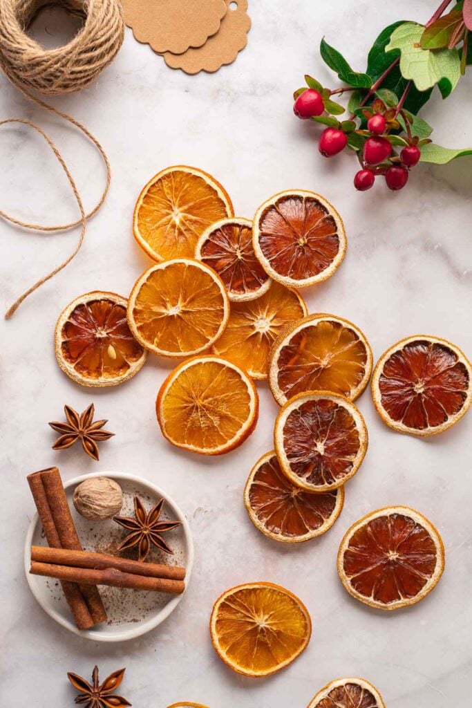 Slices of dried oranges and lemons arranged on a light surface.